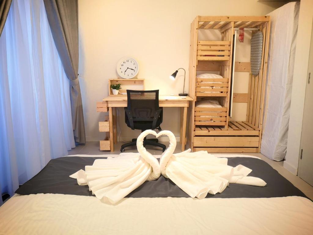 塞贝维Tamarind Suites by BeeStay Management的一间卧室配有一张带心形毛巾的床