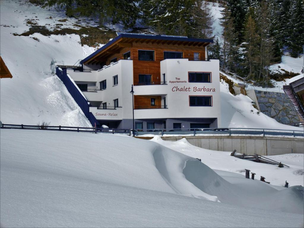 伊施格尔芭芭拉公寓的滑雪场前有雪坡的建筑物