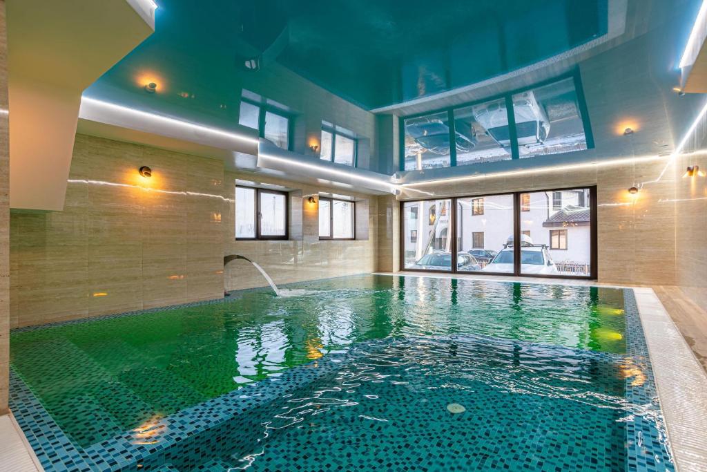 布克维Amarena SPA Hotel - Breakfast included in the price Spa Swimming pool Sauna Hammam Jacuzzi Restaurant inexpensive and delicious food Parking area Barbecue 400 m to Bukovel Lift 1 room and cottages的游泳池,位于带泳池导览器的建筑内