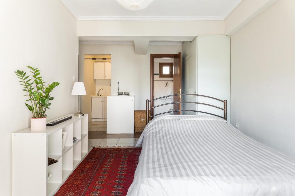 塞萨洛尼基Irodotou Studio的一间白色卧室,配有一张床和红色地毯