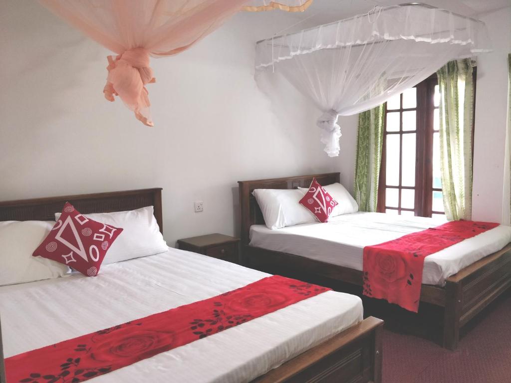 哈顿Top View的一间卧室配有两张红色和白色床单