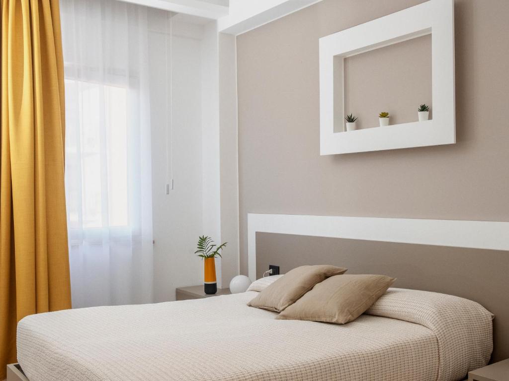 切法卢Liolá Cefalù的一间卧室配有一张带镜子和黄色窗帘的床
