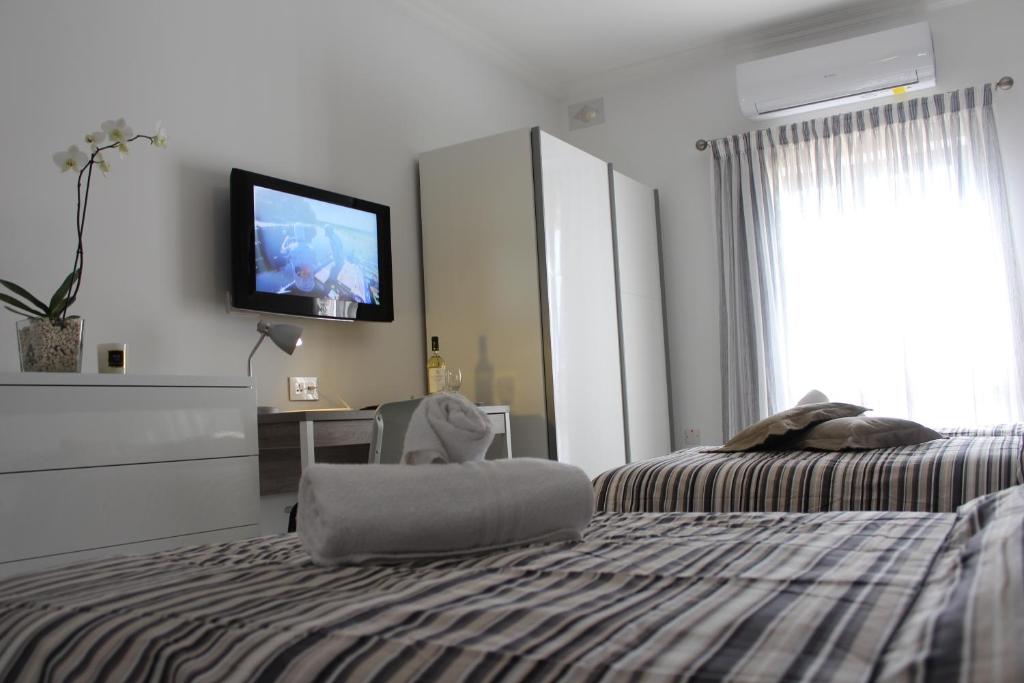梅利哈Cosy Home的卧室配有一张床,墙上配有电视。