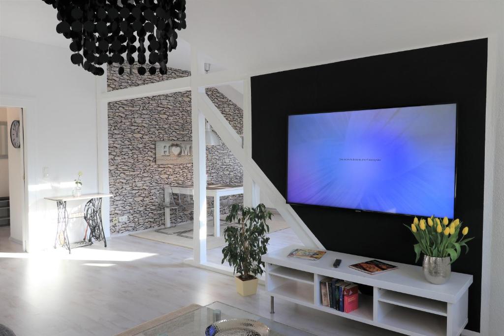 鲁尔河畔米尔海姆Ferienwohnung Villa Ruhr的客厅配有壁挂式大屏幕平面电视