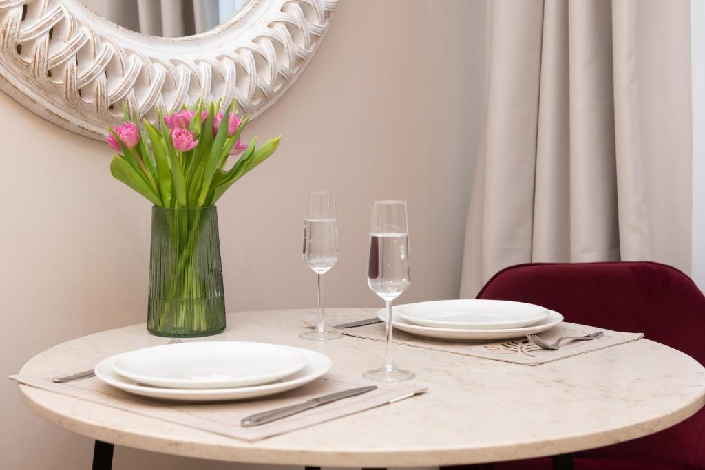 塔林Hotel Meltzer Apartments的桌子,上面有盘子,玻璃杯,花瓶