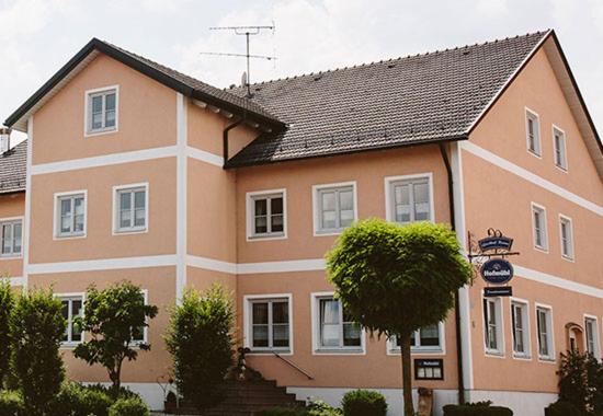 OchsenfeldGasthof Krone Ochsenfeld的一座大型的橙色和白色建筑,有黑色的屋顶