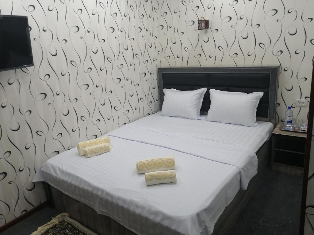 撒马尔罕Aziz Hotel的一间卧室配有一张床,上面有两条毛巾
