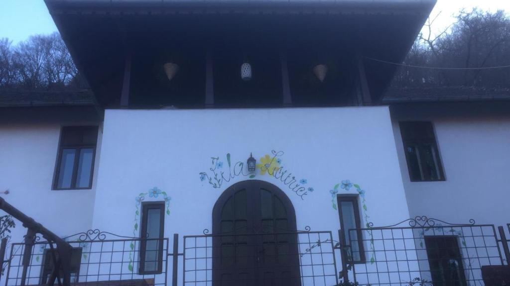 卡库拉塔Vila Licurici的白色的建筑,有门和标志