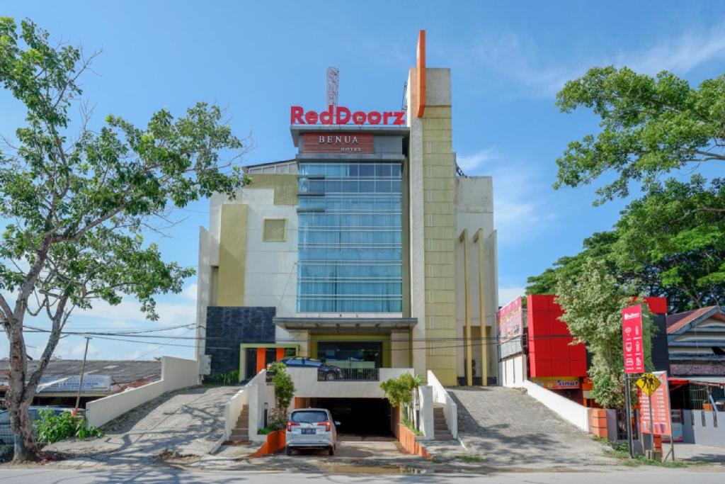 PulupandaRedDoorz Plus near Hotel Benua Kendari的上面有红色的罗伯克标志的建筑