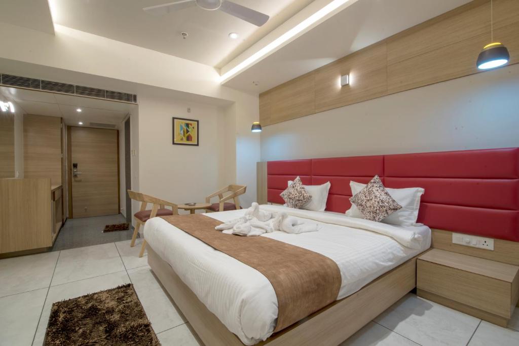 艾哈迈达巴德HOTEL SILVERA GRAND的一间卧室配有一张大床和红色床头板