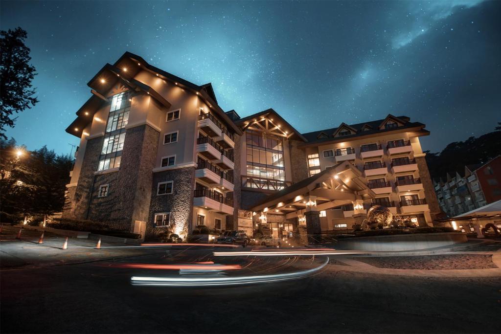 碧瑶碧瑶阿德利亚公寓酒店的一座在晚上有灯的大建筑