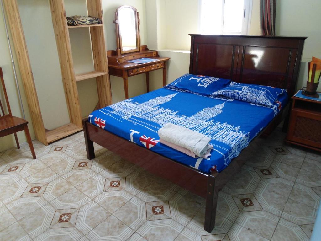 圣丹尼斯Chambres D'hôtes AISSA的一间卧室配有一张带蓝色棉被的床
