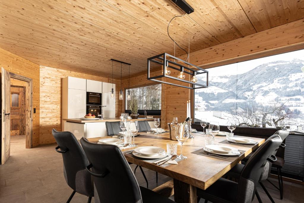 菲根Naturlodge Tirol - Naturverbunden im Zillertal的厨房以及带木桌和椅子的用餐室。