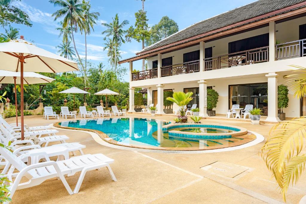 拉迈皇家小屋住宿酒店的一个带游泳池和椅子的度假胜地和一座建筑