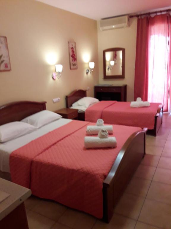 奥林匹亚基·阿克蒂Olympic Studios Aslanidis的两张位于酒店客房的床铺,配有红色床单