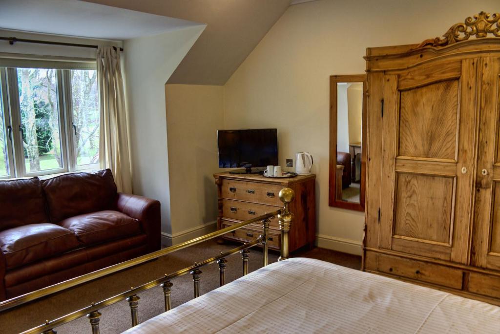 塞得利斯坎贝斯德尔斯姆高尔夫酒店的一间卧室配有一张床、一张沙发和一面镜子