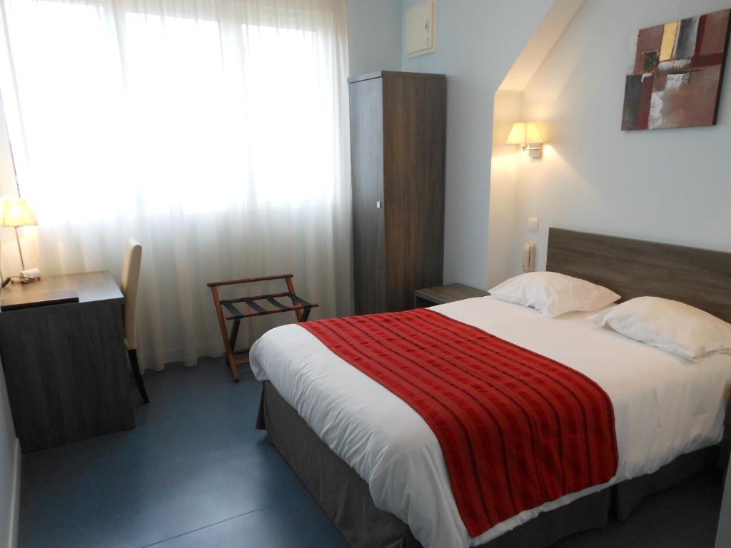 卢瓦尔河畔新堡公园酒店的酒店客房设有一张带红色毯子的大床