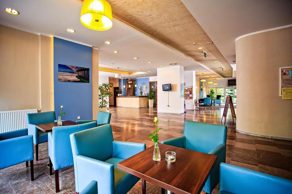 卡尔帕奇Hotel Karolinka的大堂内的餐厅,配有蓝色的桌椅