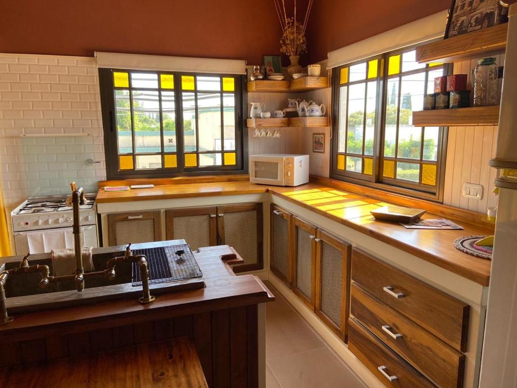 洛博斯El Refugio的厨房配有木制橱柜、水槽和窗户。