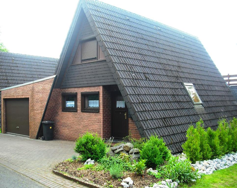 DriedorfFerienhaus Mauer Krombachtalsperre, exclusive Nebenkosten Strom的一座带黑色屋顶和花园的房屋
