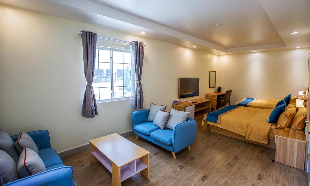 塞班Residence Lodge的一间卧室配有一张床、一张沙发和一台电视。