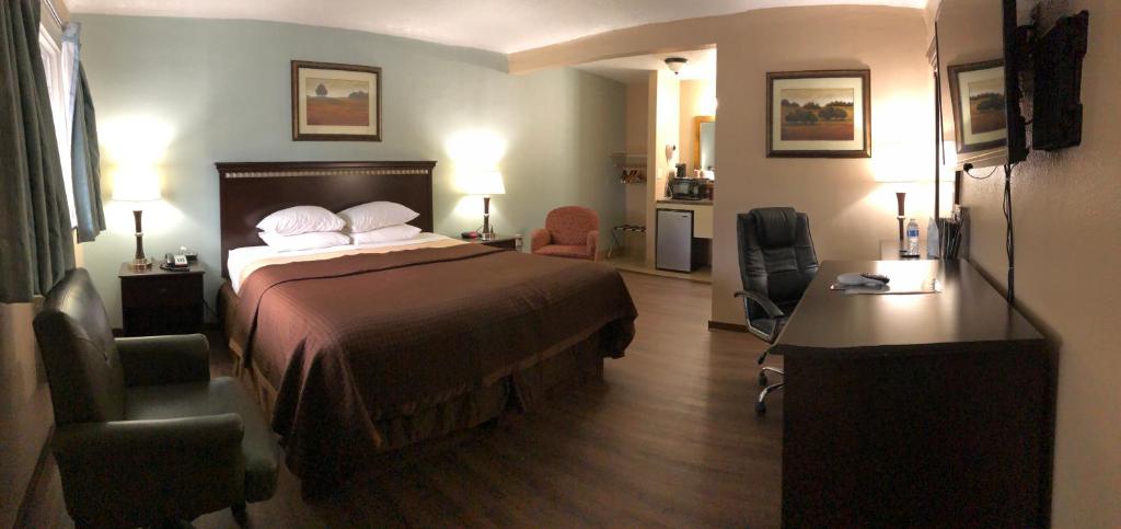尤金Value Inn Motel EUGENE AIRPORT的配有一张床和一张书桌的酒店客房