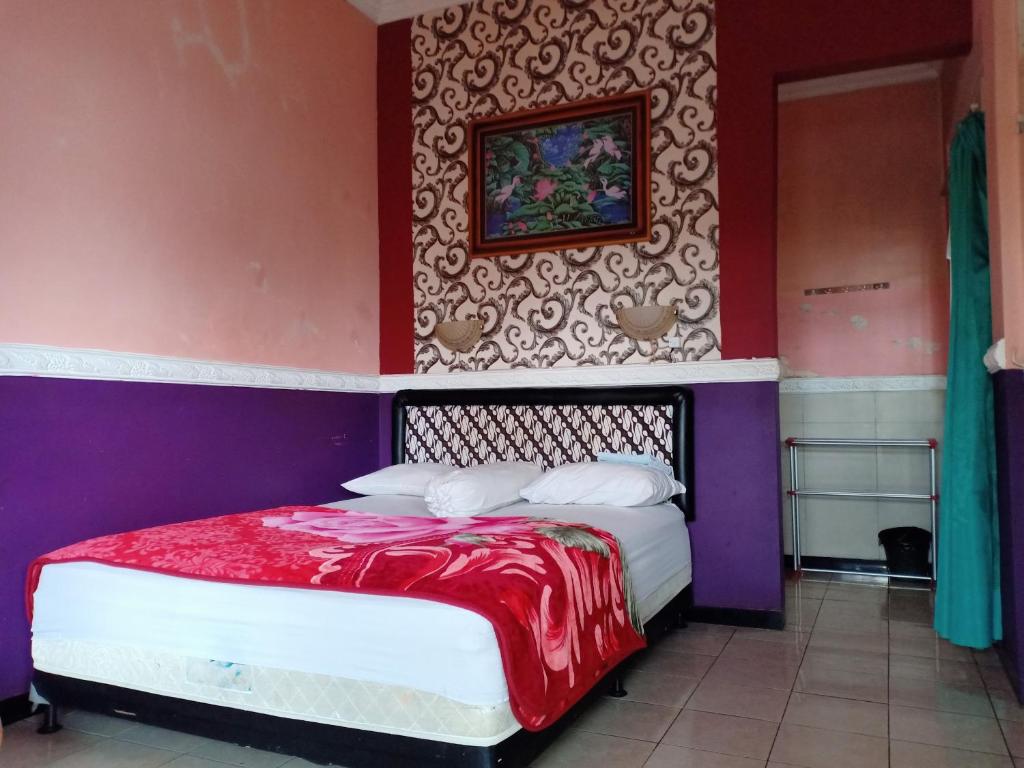 萨兰甘OYO 3020 Penginapan Citra Rasa的一间卧室配有一张床铺,床上铺有红色毯子