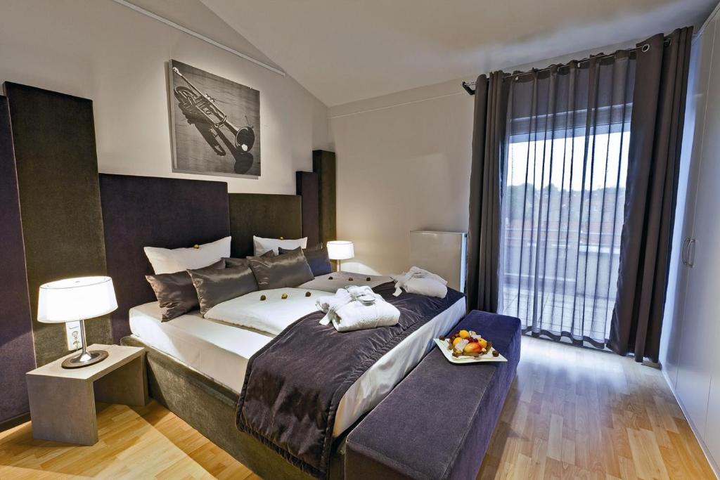 亚琛卓越艺术酒店的一间卧室设有一张大床和一个大窗户