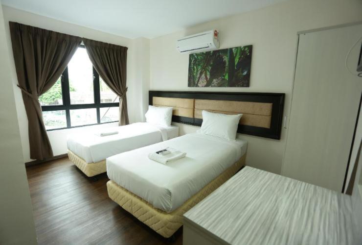 安邦Yeob Bay hotel Ampang的酒店客房设有两张床和窗户。