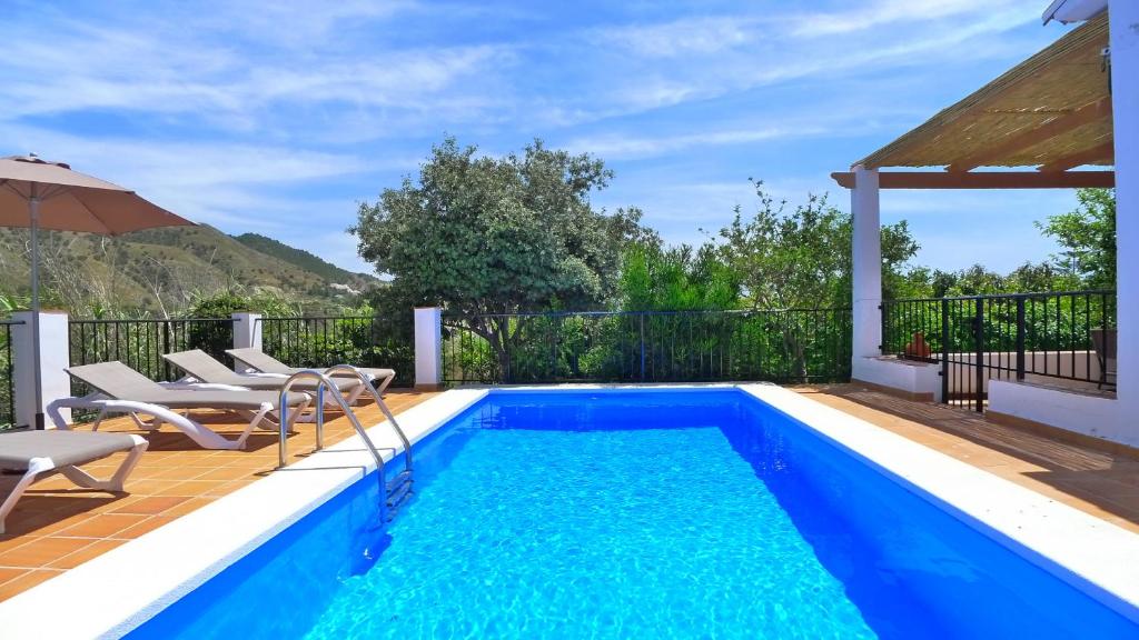 弗里希利亚纳Villa Jazmin - C&G的房屋旁的游泳池配有椅子和遮阳伞
