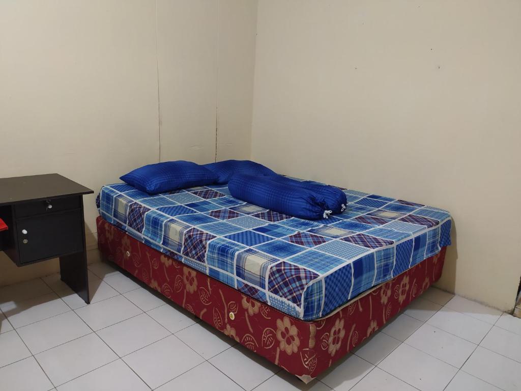 马卡萨OYO 3116 Batu Putih Homestay的一张床上有蓝色枕头的睡床