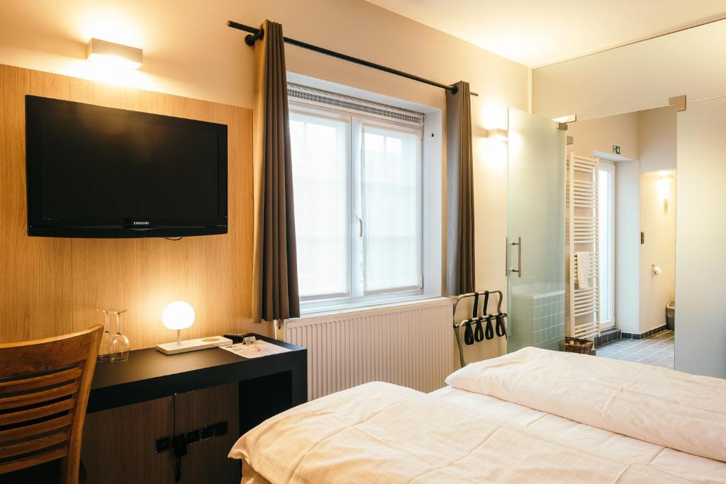 卡斯特尔莱Guesthouse De Casteleer的配有一张床和一台平面电视的酒店客房