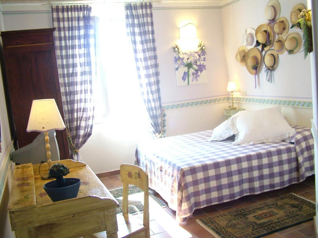 Lanuvio梅里迪安娜农家乐的一间卧室配有一张床、一张桌子和一个窗户。