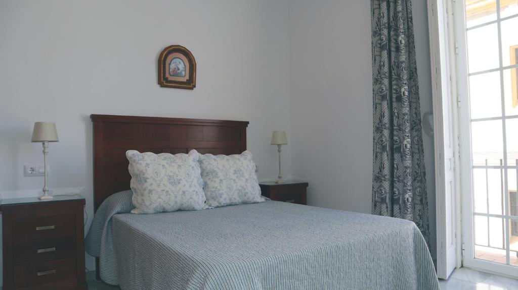桑卢卡尔-德巴拉梅达Apartamento en el centro的一间卧室设有一张床和一个窗口