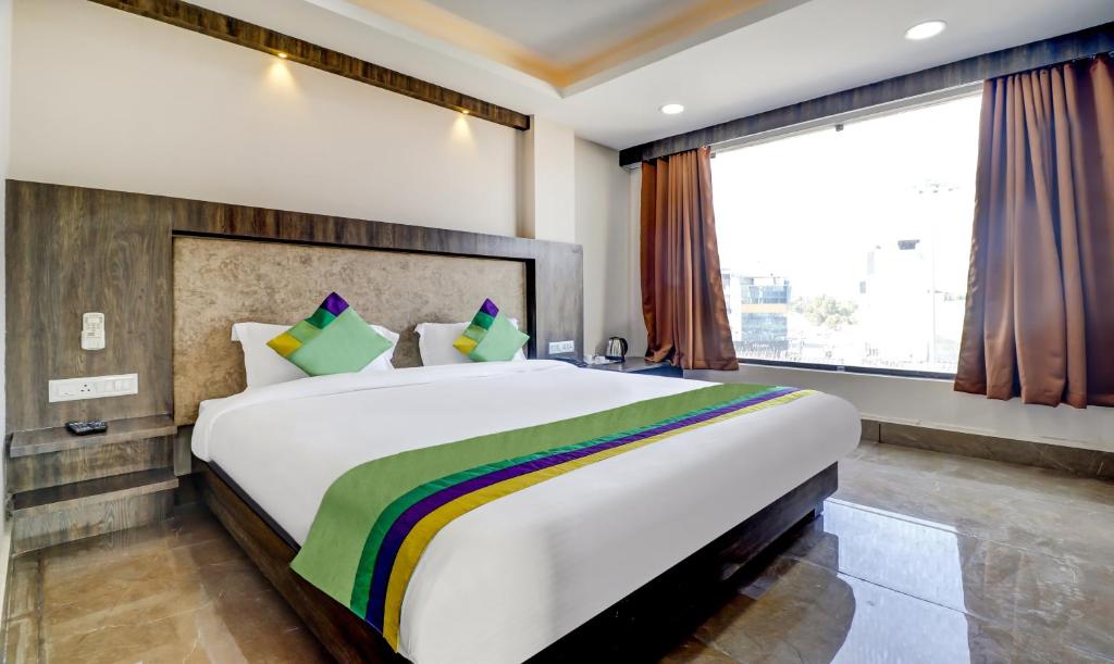 比卡内尔Hotel Bikalal, Bikaner的一张大床,位于带大窗户的房间里