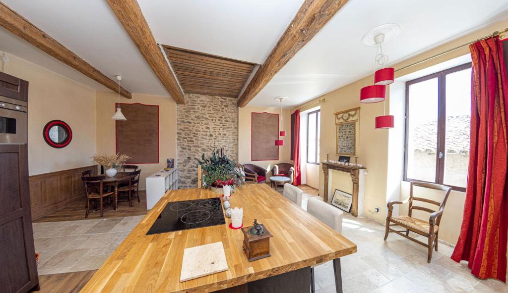 佩兹纳斯La Comédie de Pézenas - Appartements的厨房以及带木桌的起居室。