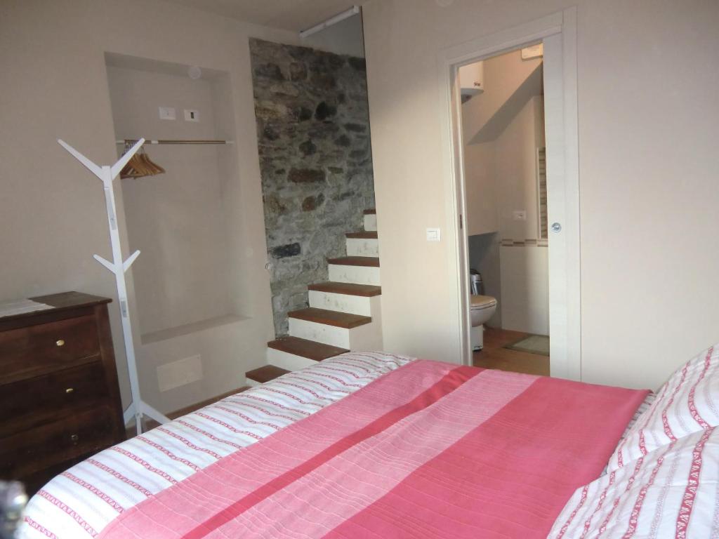 瓦拉洛LA PICCIONAIA的一间卧室设有一张床和一个石楼梯