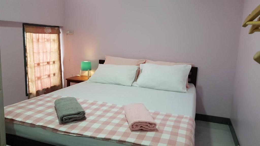 曼谷Baan U-Sabai บ้านอยู่สบาย的一间卧室配有一张床,上面有两条毛巾