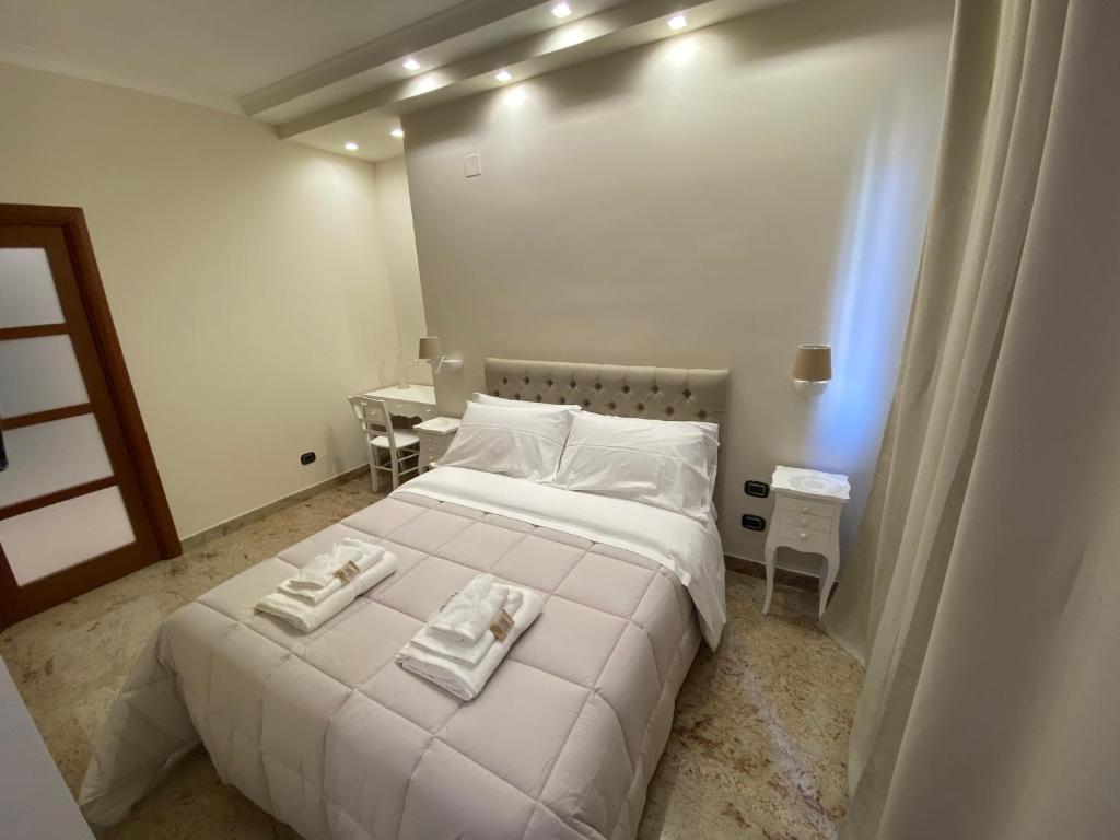 福贾B&B San Michele Foggia的卧室配有白色的床和2条毛巾