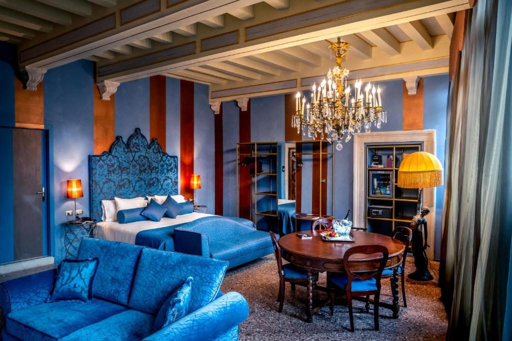 威尼斯Excess Venice Boutique Hotel & Private Spa - Adults Only的一间卧室配有一张床、一张桌子和蓝色的家具
