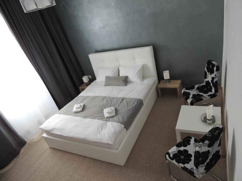 克卢日-纳波卡沙达旅馆的一间小卧室,配有白色的床和椅子