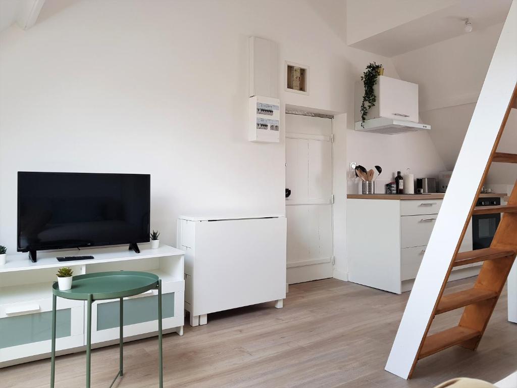Déville-lès-RouenFleuryBis - Appartement calme proche de Rouen的一间白色的小厨房,内配电视和凳子