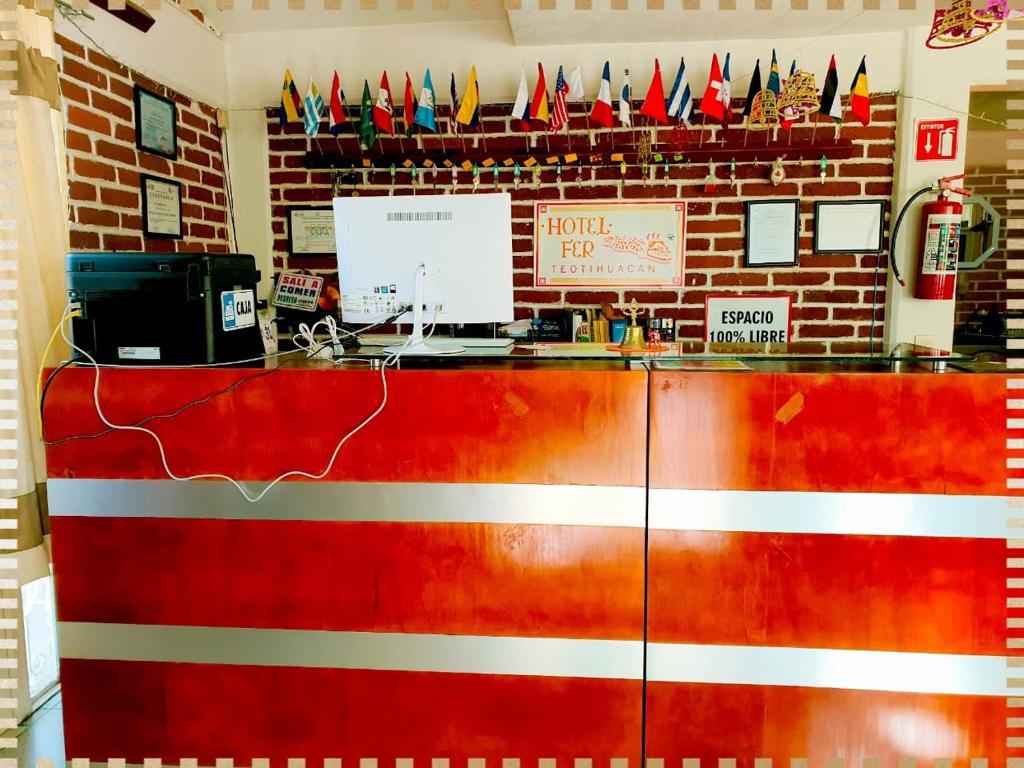 圣胡安特奥蒂瓦坎Hotel Fer的墙上挂着旗帜的餐厅里的红色柜台