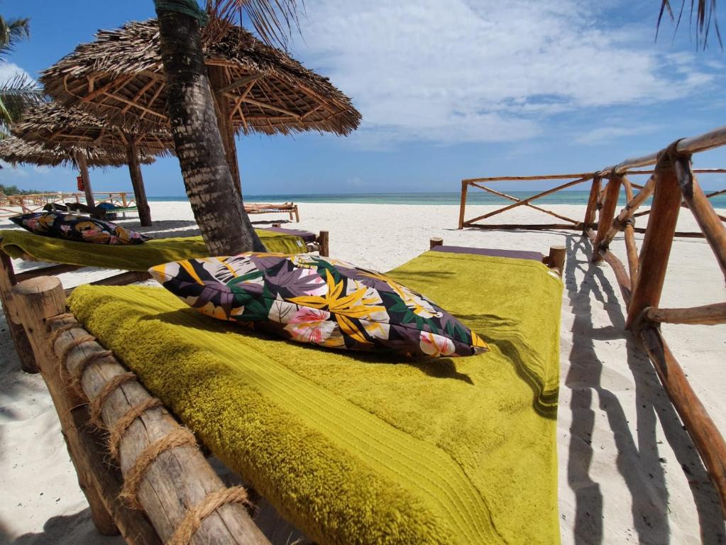 普瓦尼梅查恩加尼MOYO apartment的海滩上的一张带遮阳伞的床铺