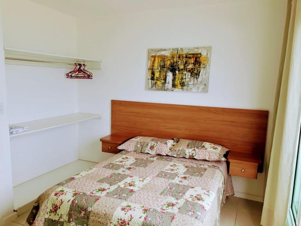 卡波布里奥Casa NA PRAIA do Peró的一间卧室配有一张带木制床头板的床