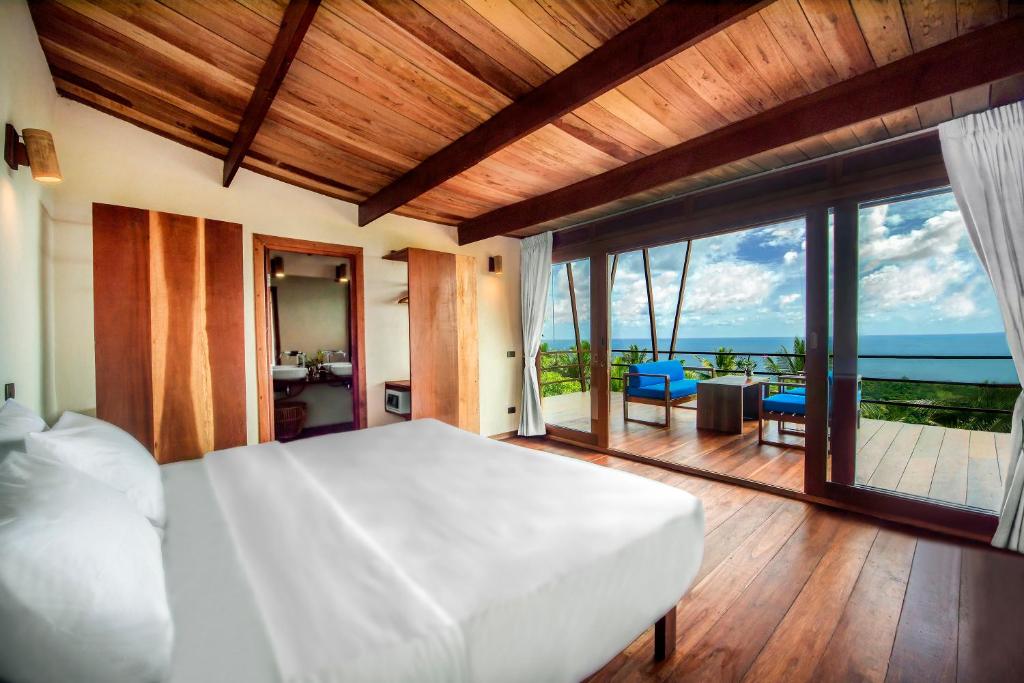 涛岛Ecotao Lodge的一间卧室配有一张床,享有海景