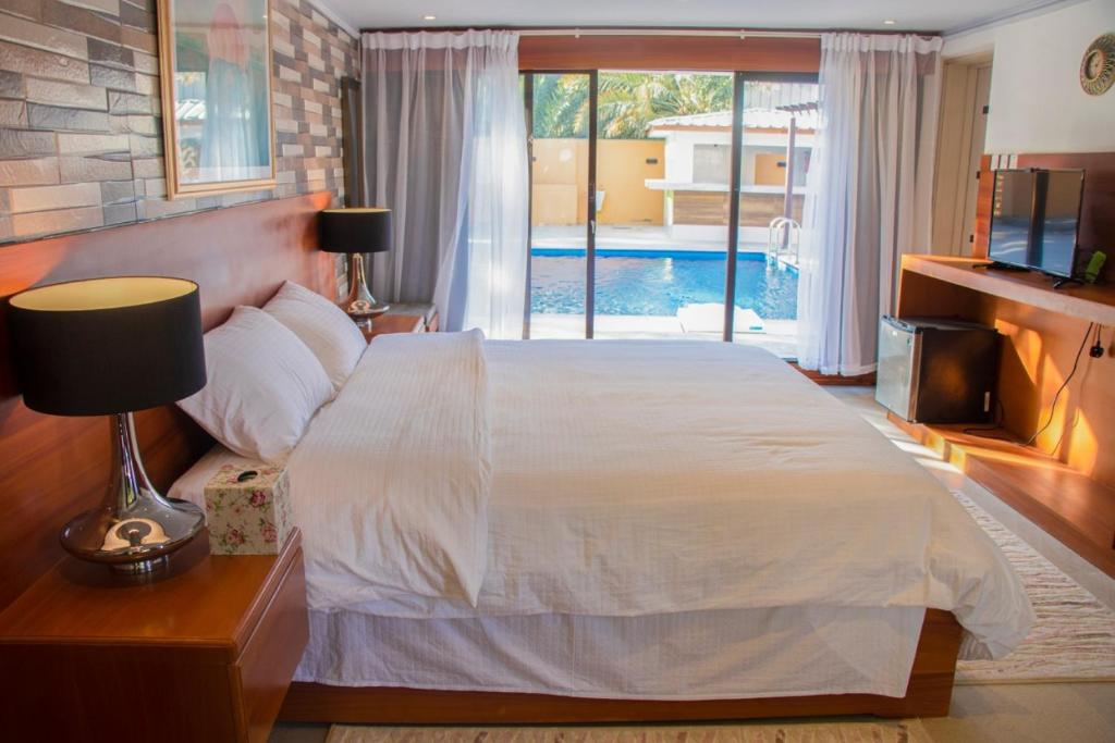 尼兹瓦The Inn Nizwa的一间带大床的卧室和一个游泳池