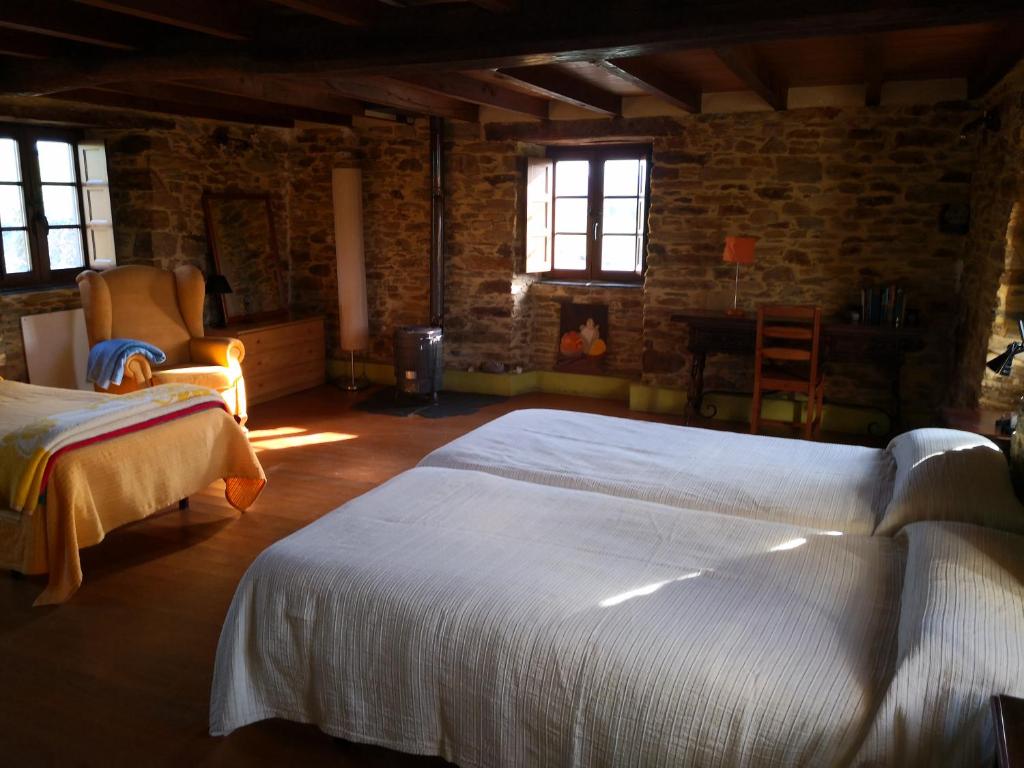 ReirizCasa a Pedra的一间卧室设有两张床、一把椅子和窗户。