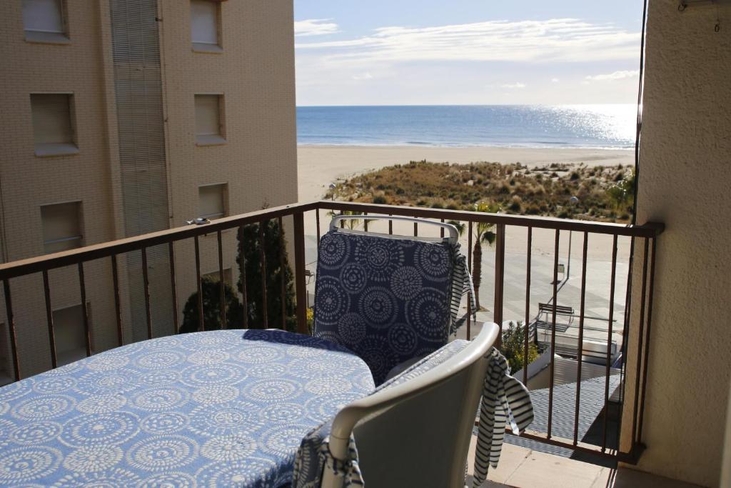 托里代巴拉AT060 Torremar II的阳台配有桌子,享有海滩美景