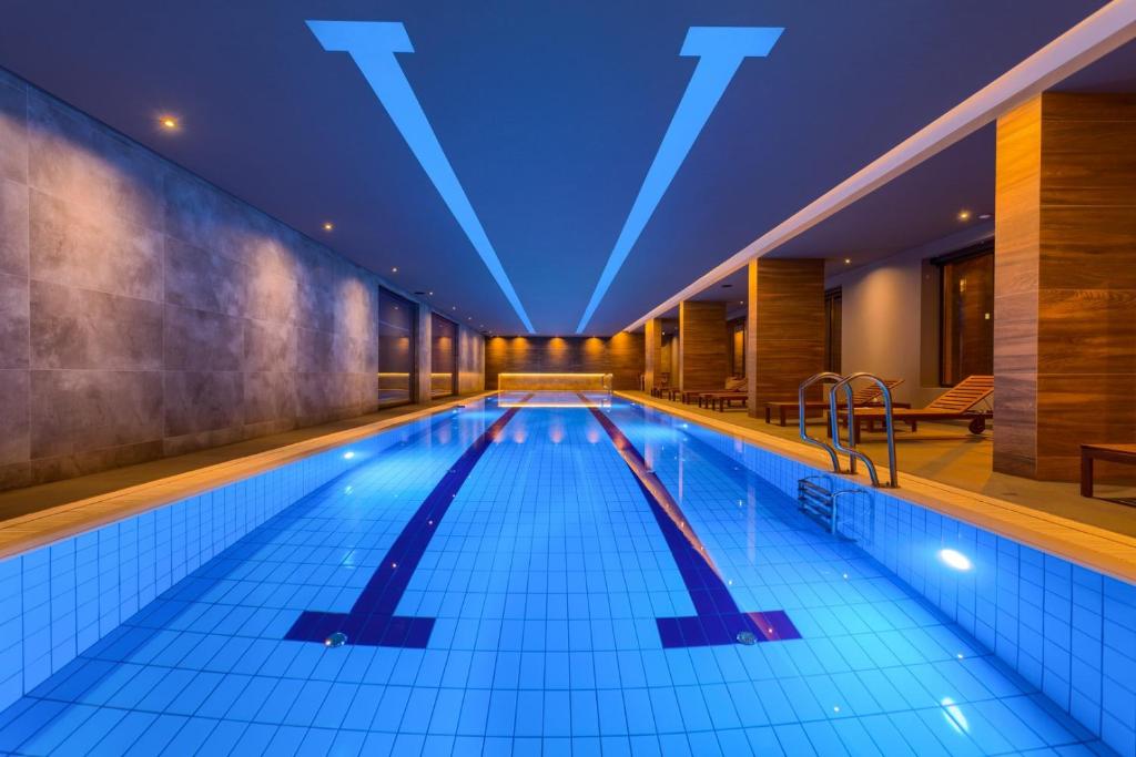 兹拉蒂博尔Kalman SPA&GYM的大楼内带蓝色灯光的大型游泳池